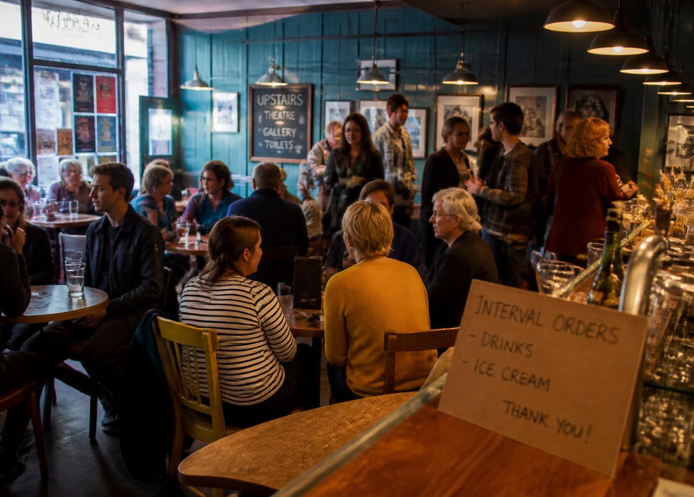 The Kestrel cafe-bar filling up before doors, warm pendant lamps over mismatched tables