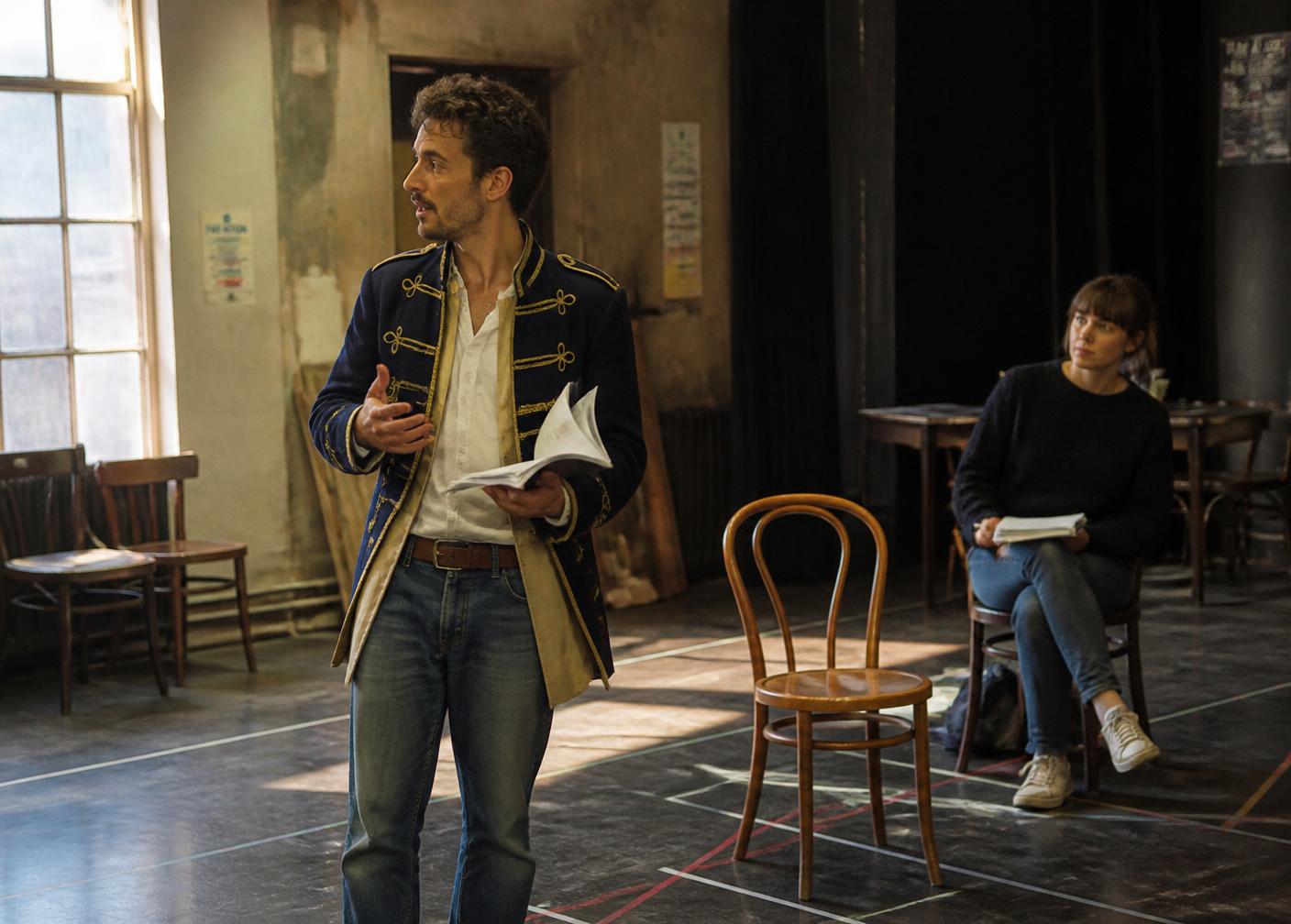 An actor in half-costume working in the Kestrel rehearsal room, script in hand
